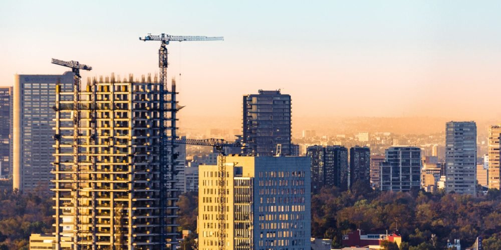 pexels-photo-15937637-15937637 Aerial view of construction cranes and skyscrapers in Ciudad de México at sunset.